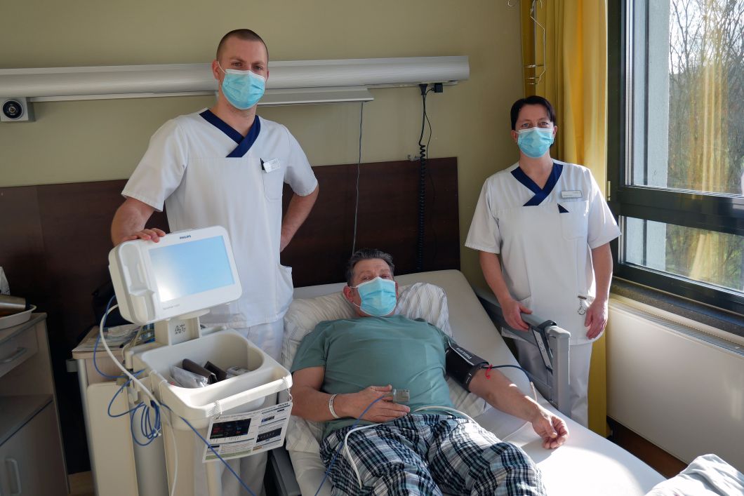 (v.l.n.r.): Dominik Nellessen (links) und Stefanie Schlütz (rechts) messen bei unserem Patienten Michael Lemmrich mit dem neuen Vitalparameter-Monitor den Blutdruck.